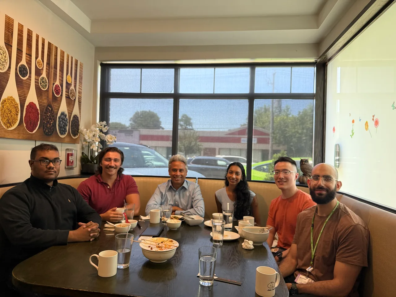 Six lab members sitting around a restaurant table at the end of lunch